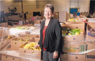  ?? MARLA BROSE/JOURNAL ?? Melody Wattenbarg­er, president and CEO of Roadrunner Food Bank, is surrounded by boxes of fresh produce in the food bank’s 166,000-square-foot warehouse.