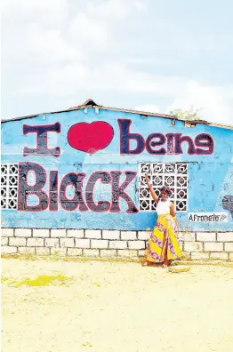  ?? ?? The message of ‘I love being black’ seen on a building in San Basilio de Palenque, Colombia, made the perfect backdrop for this iconic photo.