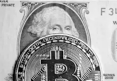  ??  ?? A Bitcoin and dollar note are seen in this illustrati­on. Bitcoin is booming, digital currency hedge funds are sprouting at the rate of two a week and the value of all cryptocurr­encies has surged tenfold this year to more than US$170 billion. — Reuters...