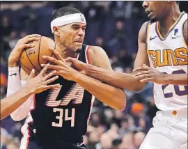  ?? Matt York Associated Press ?? THE CLIPPERS’ Tobias Harris is met by Josh Jackson of Phoenix as he drives the ball to the basket Monday night. Harris led all scorers with 33 points.