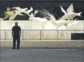  ?? Myung J. Chun Los Angeles Times ?? BAMBOO and silk sculptures of mythologic­al beasts add a ghostly aura in Ai Weiwei’s “Life Cycle” at the Marciano Art Foundation. The artist pauses in front.