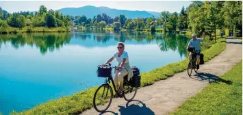  ??  ?? Stauseen und Kanäle prägen die Radtour von den Alpen zur Donau. Unser Bild zeigt zwei Radwandere­r mit ihren E Bikes am Isar stausee bei Bad Tölz.