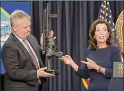  ?? Associated Press ?? State Police Superinten­dent Kevin Bruen displays a firearm at a news conference Wednesday where Gov. Kathy Hochul laid out plans to address gun violence and radicaliza­tion.