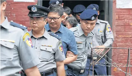  ?? EPA-EFE ?? Reuters journalist Wa Lone is escorted by police officers as he leaves the court during a break in his trial in Yangon, Myanmar.