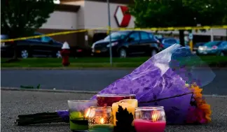  ?? ?? Flowers and candles lay outside the scene of a shooting at a supermarke­t in Buffalo.