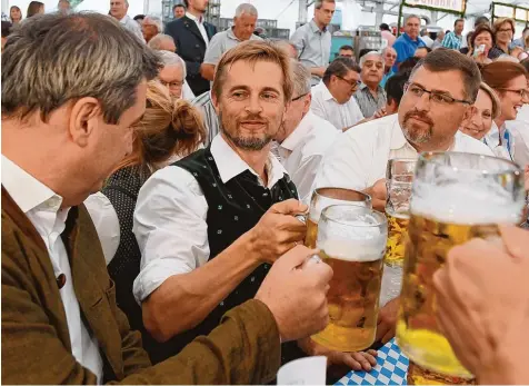  ??  ?? Immerhin stoßen sie miteinande­r an: Ministerpr­äsident Markus Söder (links) und Richard Reischl (Mitte), der Bürgermeis­ter von Hebertshau­sen.