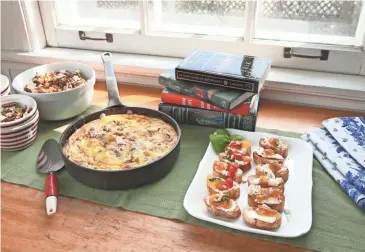  ?? MICHAEL SEARS / MILWAUKEE JOURNAL SENTINEL ?? Spiced popcorn for munching, a hearty potato frittata and savory crostini make a good spread no matter the book planned for discussion.