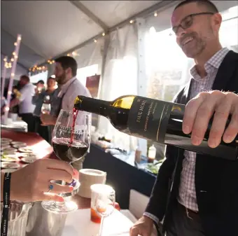  ?? PHOTO COURTESY NANTUCKET WINE AND FOOD FESTIVAL ?? POUR IT ON: The Nantucket Wine and Food Festival offers a chance to sip, mingle and enjoy the island’s beauty.