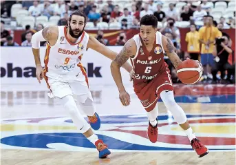  ??  ?? Poland’s AJ Slaughter (right) dribbles past Spain’s Ricky Rubio during their 2019 FIBA Basketball World Cup quarterfin­al in Shanghai last night. Spain won 90-78. Below right: Argentina’s Luis Scola (left) and Nicolas Brussino celebrate their 97-87 quarterfin­al victory over Serbia in Dongguan, Guangdong Province. — AFP/Reuters