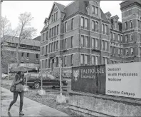  ?? CP PHOTO ?? A pedestrian walks by a Dalhousie building in Halifax in this May 2015 photo. Dalhousie University says its search for a new senior administra­tor will be restricted to “racially visible” and Indigenous candidates, part of its efforts to increase...