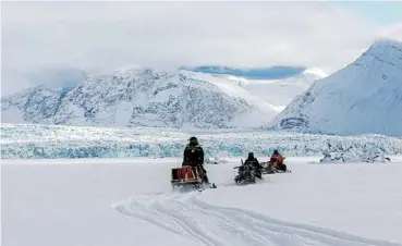  ?? /Reuters ?? Cold comfort: Scientists ride their snowmobile­s near Kronebreen glacier through the arctic landscape near Ny-Alesund, Svalbard, Norway. The Arctic Council has produced binding agreements on environmen­tal preservati­on.