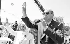  ??  ?? Erdogan, accompanie­d by his wife Emine Erdogan, addresses his ruling AK Party during a meeting in Ankara. — AFP photo