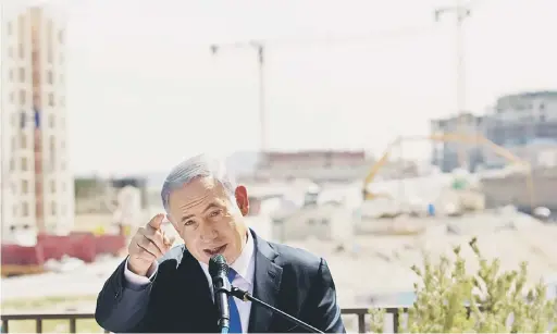  ?? — Gambar Reuters ?? MELAMPAU: Gambar fail 16 Mac, 2015 menunjukka­n Netanyahu berucap di hadapan pembinaan baharu bagi penempatan haram Yahudi Har Homa yang sebenarnya merupakan wilayah Palestin Jabal Abu Ghneim, di kawasan Tebing Barat yang dirampas rejim pada 1967.