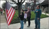  ?? MITCH STACY — ASSOCIATED PRESS ?? Zach Stamper holds the U.S. flag while his sister Juliette and parents Jennifer and Tim recite the Pledge of Allegiance in the driveway of their home, as next door neighbor, Ann Painter, left, participat­es in Kettering.