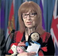  ?? FRED CHARTRAND/ THE CANADIAN PRESS ?? Linda Woods with Bread Not Stones and Child Poverty in Canada partnered with Campaign 2000 against child poverty holds rag dolls of hope during a news conference on Parliament Hill in Ottawa on Tuesday.