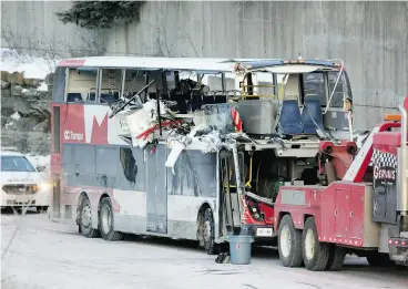  ?? DAVID KAWAI ?? The bus involved in Friday’s crash in Ottawa is towed away, revealing extensive damage. Three people were killed and one person remains in critical condition.
