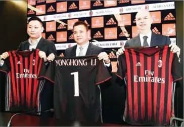  ?? MIGUEL MEDINA/AFP ?? Chinese businessma­n and new owner of the AC Milan football club Yonghong Li (centre) poses with Italian businessma­n Marco Fassone (right) and Rossoneri Sport Investment Lux representa­tive David Han Li during a press conference to present the new board...