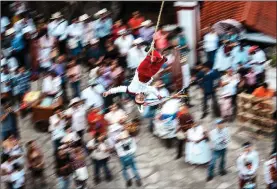  ?? ?? A volador swings over the town square of Cuetzalan.