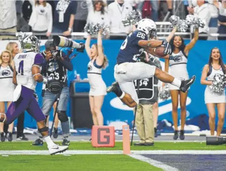  ?? Norm Hall, Getty Images ?? Penn State running back Saquon Barkley finishes a 92-yard run with a leap into the end zone Saturday in the Fiesta Bowl against Washington. He finished with 137 yards in the Nittany Lions’ 35-28 victory over the Huskies.