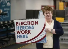  ?? RICK BOWMER — THE ASSOCIATED PRESS ?? Utah County elections director Rozan Mitchell holds an “Election Heroes Work Here” sign during a tour of Utah County's elections equipment and review processes for administer­ing secure elections in Provo, Utah, on Tuesday.