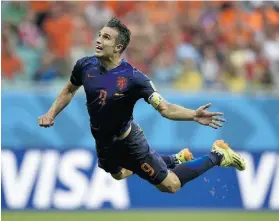  ?? LLUIS GENE/AFP/Getty Images ?? Netherland­s forward Robin van Persie scores during a Group B football match Friday against Spain at the Fonte Nova Arena in Salvador, Brazil.