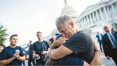  ?? DREW ANGERER/GETTY ?? Comedian and activist Jon Stewart hugs Rosie Torres, wife of veteran Le Roy Torres, who suffers from illnesses related to his exposure to burn pits in Iraq, after the Senate passed the PACT Act on Tuesday in Washington, D.C.