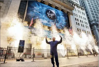  ?? RICHARD DREW — THE ASSOCIATED PRESS FILE ?? Sir Richard Branson, founder of Virgin Galactic, poses for a photo Oct. 28outside the New York Stock Exchange as fireworks are exploded before his company’s IPO. In 2020, NASA Administra­tor Jim Bridenstin­e said space is a $400billion market, including satellites. Opening up spacefligh­t to paying customers, he said, could expand the market to $1trillion.