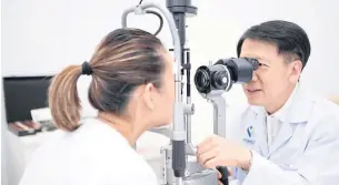  ?? ?? Dr Amporn carries out an eye examinatio­n as part of a Lasik surgery procedure.