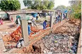  ?? PTI ?? Workers construct a wall in front of a slum ahead of Donald Trump’s visit to Ahmedabad. —