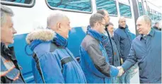  ?? FOTO: ALEXEI NIKOLSKY/IMAGO IMAGES ?? Russlands Präsident Wladimir Putin (rechts) begrüßt Arbeiter, die am Bau der Bahntrasse beteiligt waren.