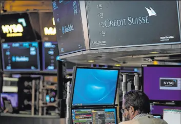  ?? Seth Wenig The Associated Press ?? A sign Wednesday displays the name of Credit Suisse on the floor at the New York Stock Exchange. Shares of the Swiss bank plunged.