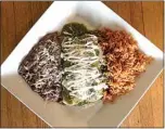  ??  ?? Enchiladas verdes are stuffed with chile verde then topped with more of the pork stew, sour cream and cheese and served with rice and beans.