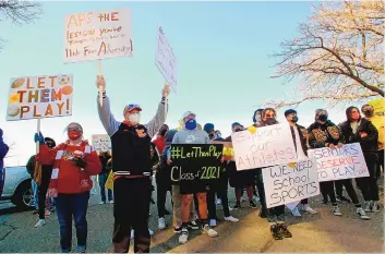  ?? ADOLPHE PIERRE-LOUIS/JOURNAL ?? Parents, athletes and supporters hold signs during a protest Sunday in response to a decision by the Albuquerqu­e Public Schools board to keep students learning virtually, which keeps sports off the table for now.