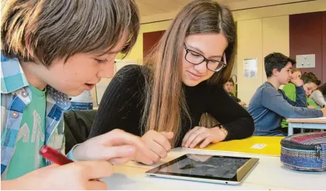  ??  ?? Der 13 jährige Thomas und seine Klassenkam­eradin, die 14 jährige Kim, arbeiten im Unterricht mit der Schul Cloud.