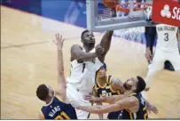  ?? AP photo ?? The Pelicans’ Zion Williamson goes to the basket over Utah’s Georges Niang and
Rudy Gobert during New Orleans’ win over the Jazz on Monday.