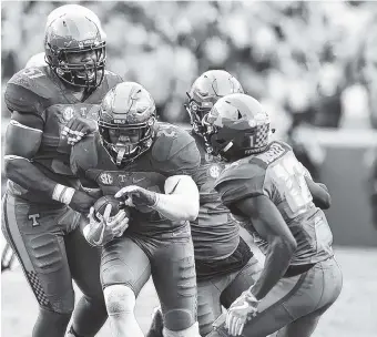  ?? STAFF FILE PHOTO BY ROBIN RUDD ?? The Tennessee defense surrounds Todd Kelly Jr. as he comes up with an intercepti­on against Florida on Sept. 24 at Neyland Stadium. Kelly said poor communicat­ion is the biggest factor in the team’s shaky run defense.