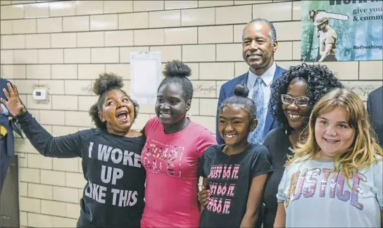  ?? Andrew Rush/Post-Gazette ?? Students with TRAILS Ministry after-school program pose for a photo with U.S. Department of Housing and Urban Developmen­t Secretary Ben Carson on Monday in Ambridge. Visit post-gazette.com for a video from his visit.