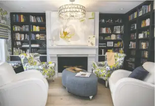  ?? ?? On the second floor, the open library space features striking navy bookshelve­s and white accent chairs.