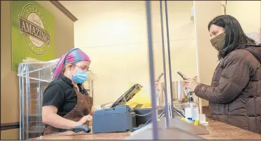  ??  ?? Leigh Barnes, right, reads her order as Mary rings her up at Opportunit­y Enterprise­s’ Simply Amazing Market. The nonprofit helps people with disabiliti­es in Lake and Porter counties.