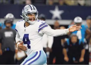  ?? Ron Jenkins / Associated Press ?? Dallas Cowboys quarterbac­k Dak Prescott hands the ball off in the second half against the Carolina Panthers last Sunday.