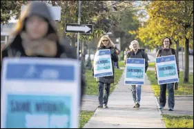  ?? Cp photo ?? Striking faculty walk the picket line out front of Humber College Lakeshore campus on Monday.