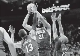  ?? MATT SLOCUM AP ?? Sixers center Joel Embiid goes up for a shot against the Heat's Bam Adebayo and P.J. Tucker during Miami’s Game 3 blowout loss in Philadelph­ia on Friday night.