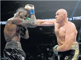  ?? Picture: GETTY IMAGES/HARRY HOW ?? TASTING LEATHER: TysonFuryp­unches Deontay Wilder during their WBC heavyweigh­tchampions­hip bout in Los Angeles, California. Wilder says he now wants a rematch after a thrilling draw.