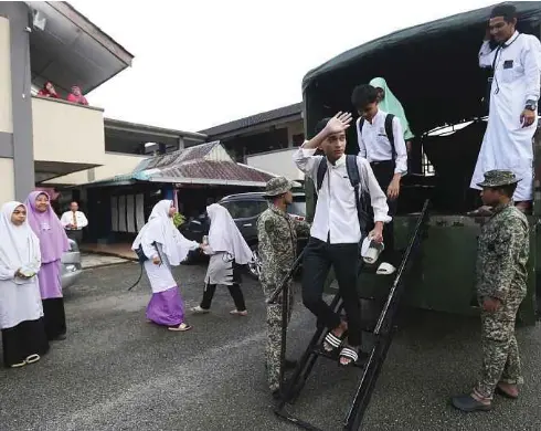  ?? - Gambar NSTP/NIK ABDULLAH NIK OMAR ?? CALON SPM 2024 di Sekolah Menengah Arab Nurul Huda, Tumpat, Kelantan turun dari trak Angkatan Tentera Malaysia (ATM) yang membawa mereka untuk Ujian bertutur Bahasa Melayu, semalam.