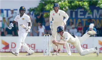  ?? — AFP ?? England’s Keaton Jennings (R) takes a catch to dismiss Sri Lanka’s Angelo Mathews (L) as Ben Foakes looks on during the second day of the opening Test at the Galle Internatio­nal Cricket Stadium.