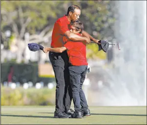  ?? Scott Audette The Associated Press ?? Tiger Woods hugs his son Charlie after finishing the PNC Championsh­ip on Sunday. Woods showed good form with his swing, but he rode a cart for all 36 holes on the relatively flat course.