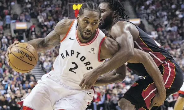  ?? CHRIS YOUNG/THE CANADIAN PRESS ?? Raptors forward Kawhi Leonard drives on the Miami Heat’s Justise Winslow last Sunday at Scotiabank Arena in Toronto. Leonard isn’t buying the hype ahead of Thursday’s showdown with Golden State, calling it “just another game to build off of and get better.”