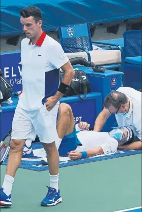  ?? FOTO: EFE ?? Bautista pasa, con Djokovic siendo tratado de molestias en el cuello