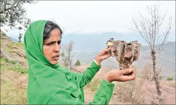  ?? — AFP photo ?? A woman holds a fin of an exploded mortar that locals say was fired by Pakistani troops in Patri village in India’s Mendhar near the Line of Control border with Pakistan.