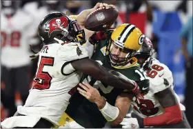  ?? THE ASSOCIATED PRESS FILE ?? Buccaneers linebacker Devin White (45) sacks Packers quarterbac­k Aaron Rodgers (12) in a game earlier this season.